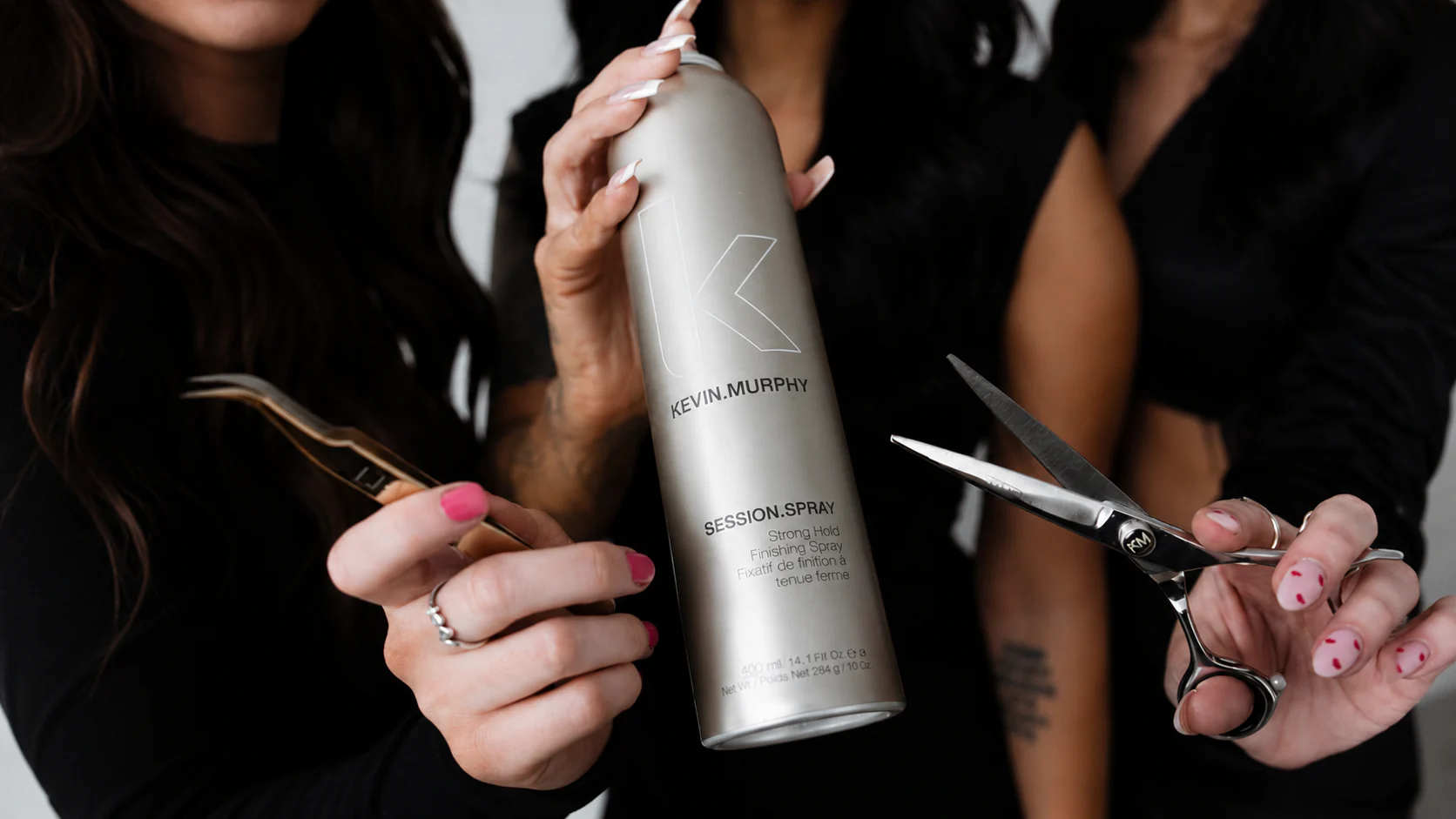 Muse Beauty Bar stylists holding Kevin Murphy finishing spray and shears