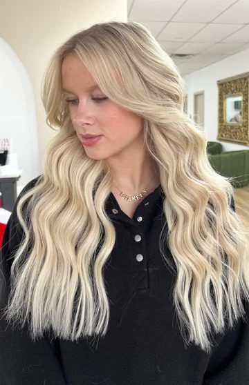 Bright blonde hair styled in long, soft waves