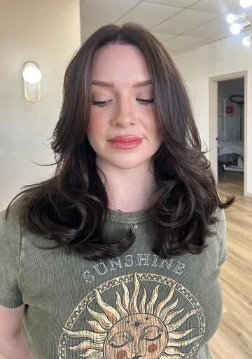 Glossy brunette haircut with bouncy face-framing layers