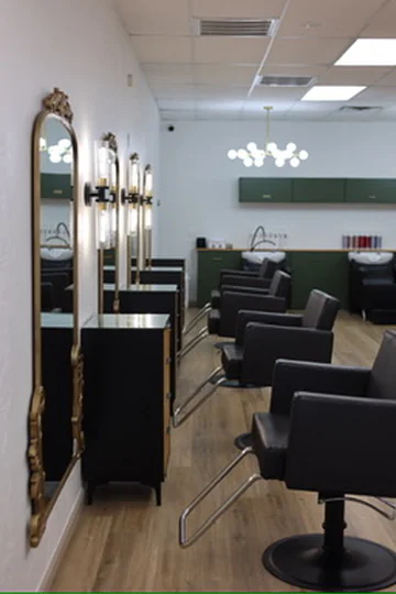 Muse styling stations with ornate gold mirrors and forest-green cabinetry